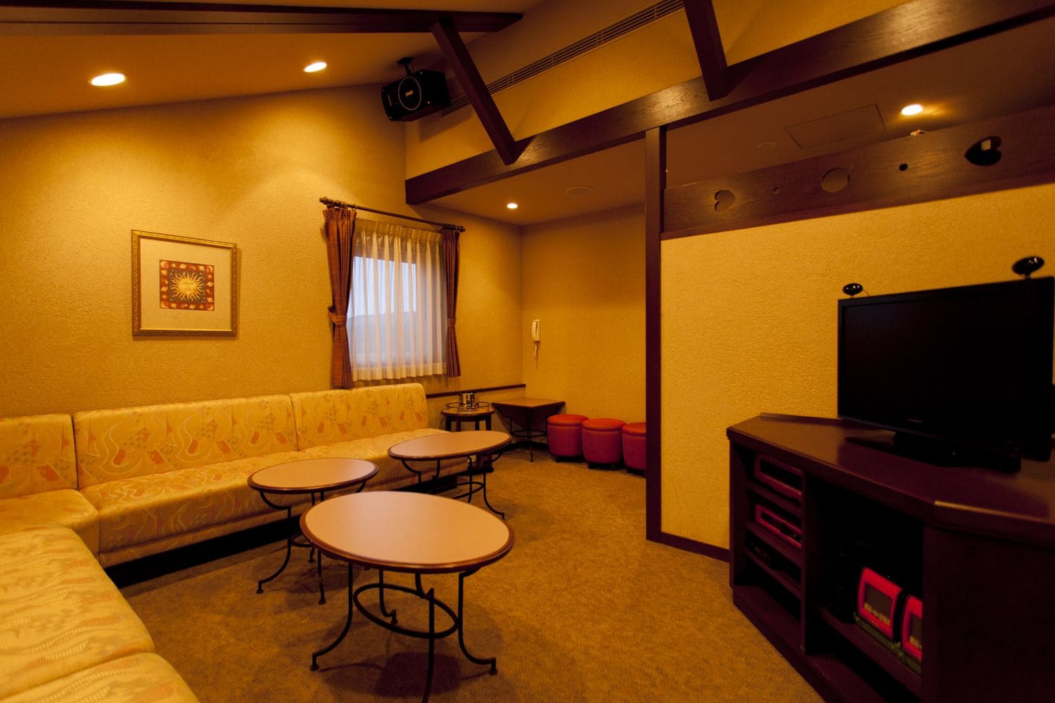 A cozy living room with a sofa, two small tables, a television, and a fireplace.