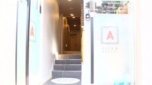 A staircase leading to a hostel with a sign indicating 'PLAN A HOSTEL'. - Plan A Hostel (Seoul)