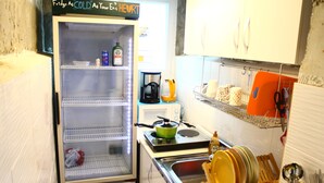 A compact kitchen with a refrigerator, stove, and sink. - Plan A Hostel (Seoul)