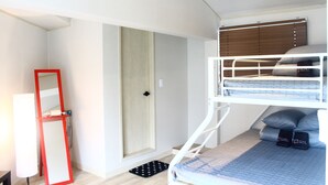A bunk bed room with a wooden door, a red-framed mirror, and a black mat on the floor. - Plan A Hostel (Seoul)