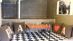 A checkered floor with a table and four pillows with letters and a heart design. - Plan A Hostel (Seoul)