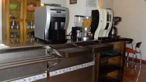 A kitchen with a coffee maker, blender, and a cabinet with glass doors. - Hotel Royal (Ronda)