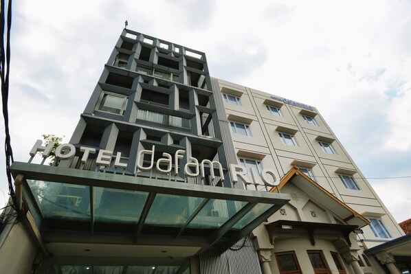 A hotel with a modern architectural design, featuring a prominent entrance with a glass canopy and a sign that reads "HOTEL Darif". - Hotel Dafam Rio (Bandung)