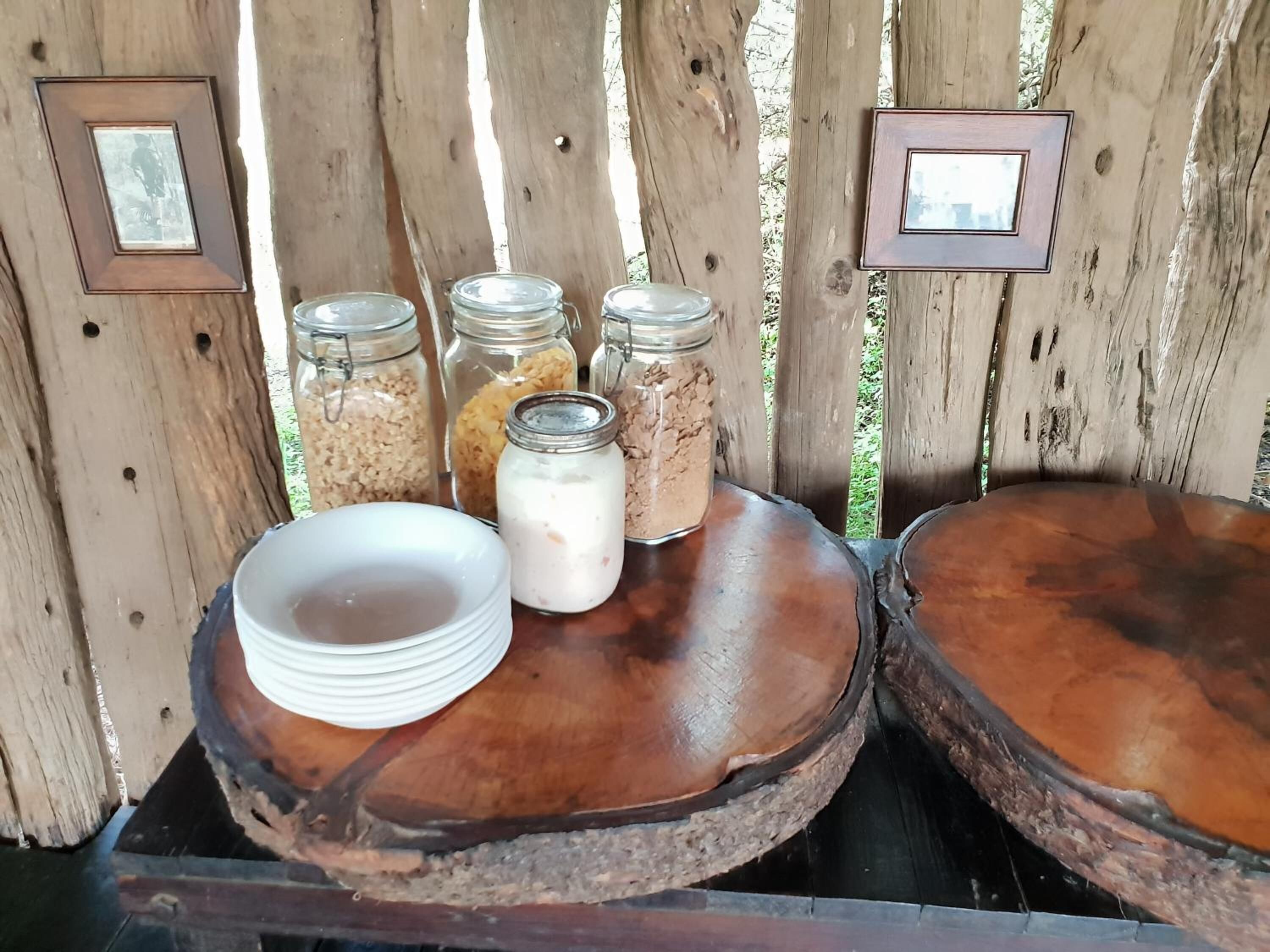 A rustic wooden table with jars of food and a white plate.