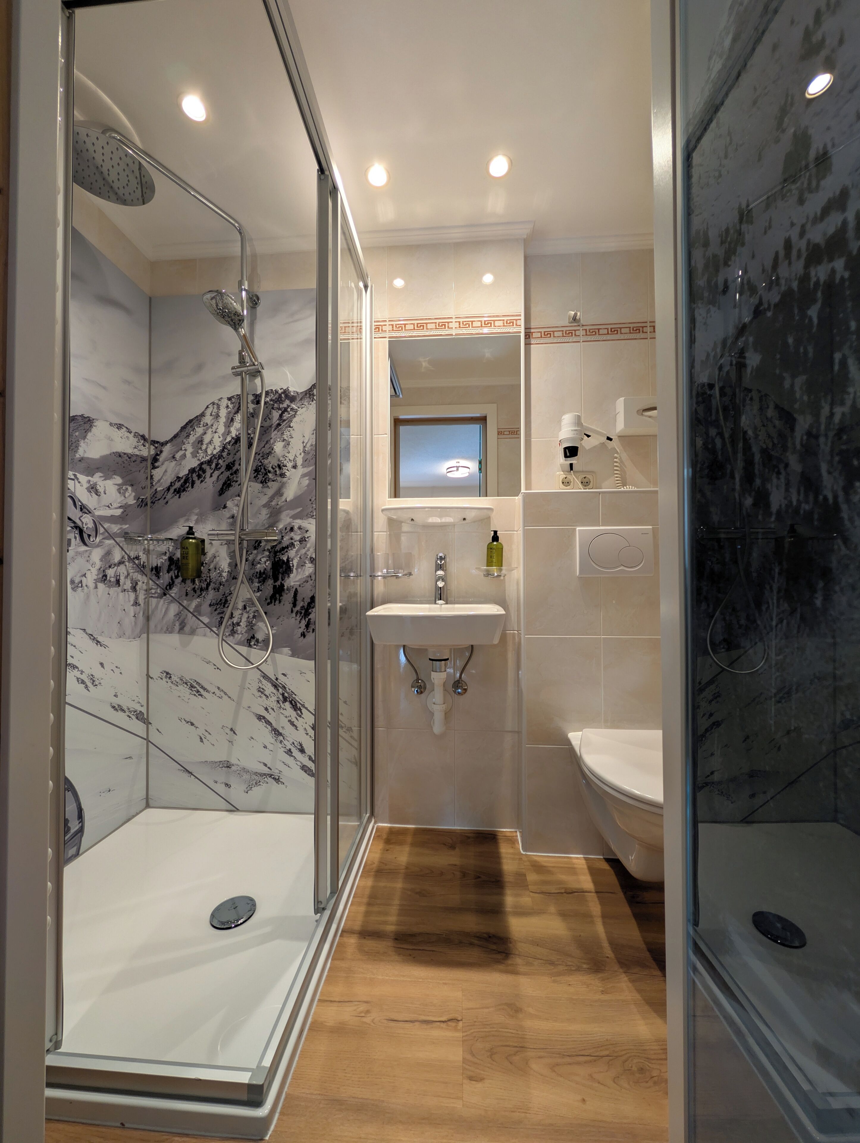 A modern bathroom with a glass-enclosed shower, a sink, and a bathtub.