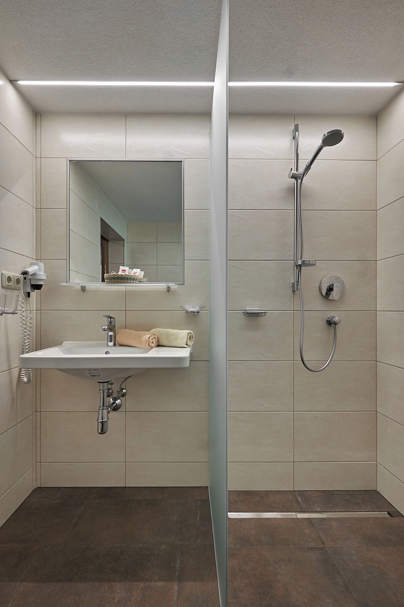 A modern bathroom with a sink, mirror, and shower.
