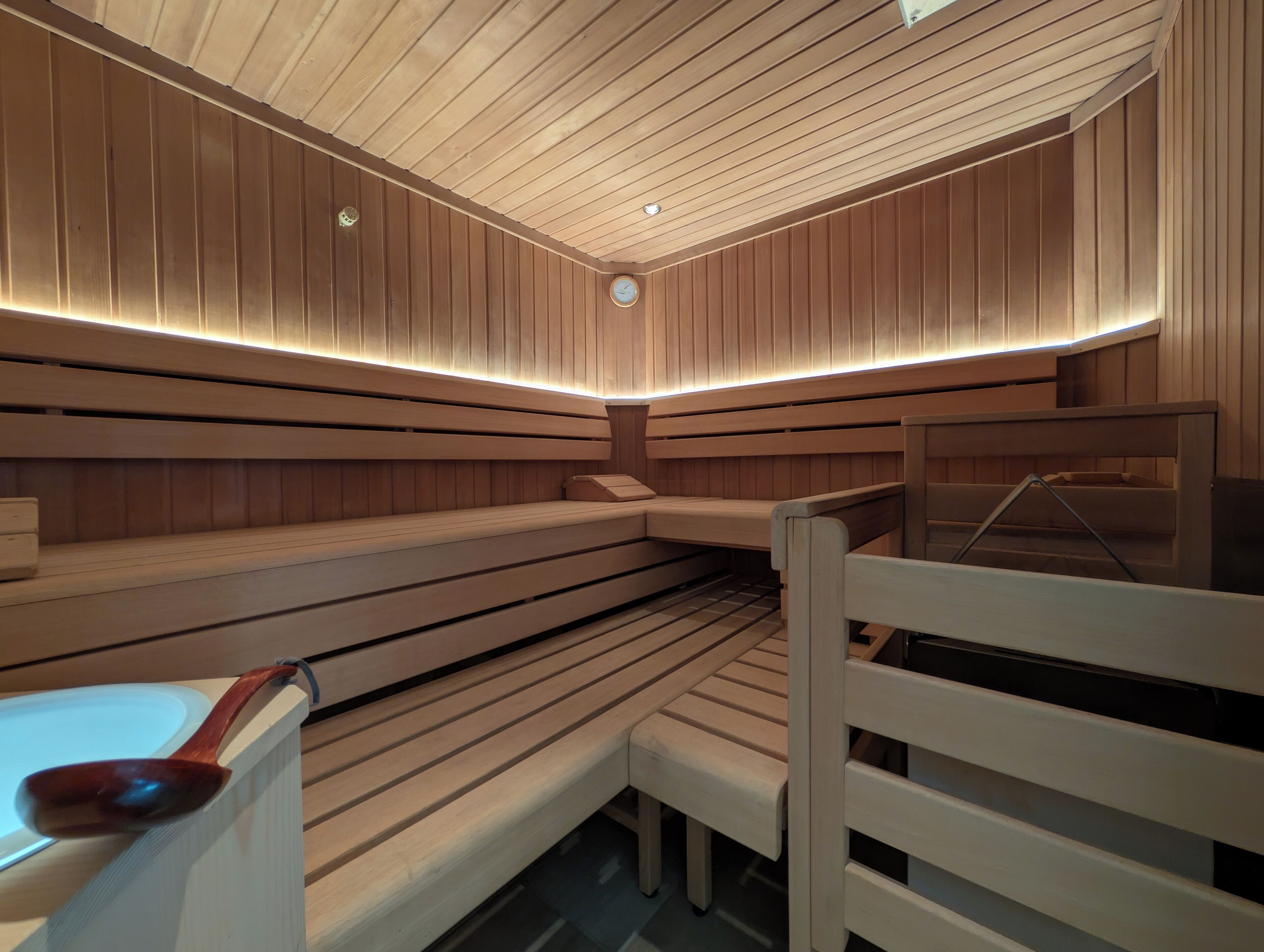 Eine Sauna mit Holzbänken und einer schrägen Decke.