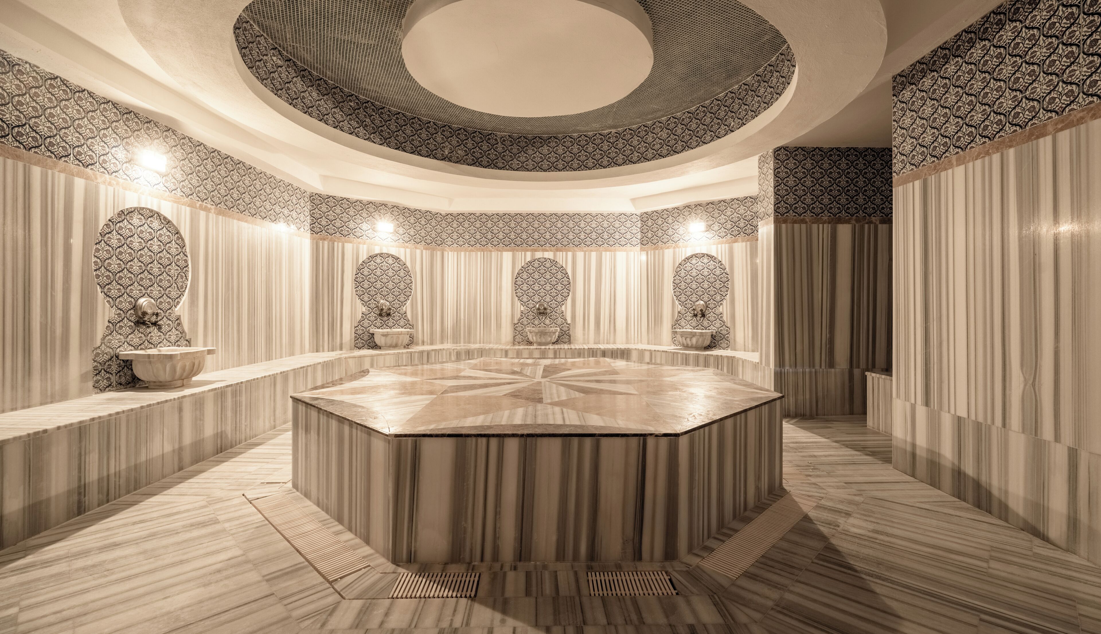 A circular spa area with a central seating area, patterned walls, and a decorative ceiling.