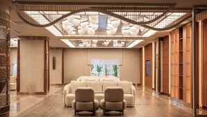 A spacious lobby with a sofa set, a staircase, and a large window with a view. - Adalya Bliss - All inclusive (Manavgat)