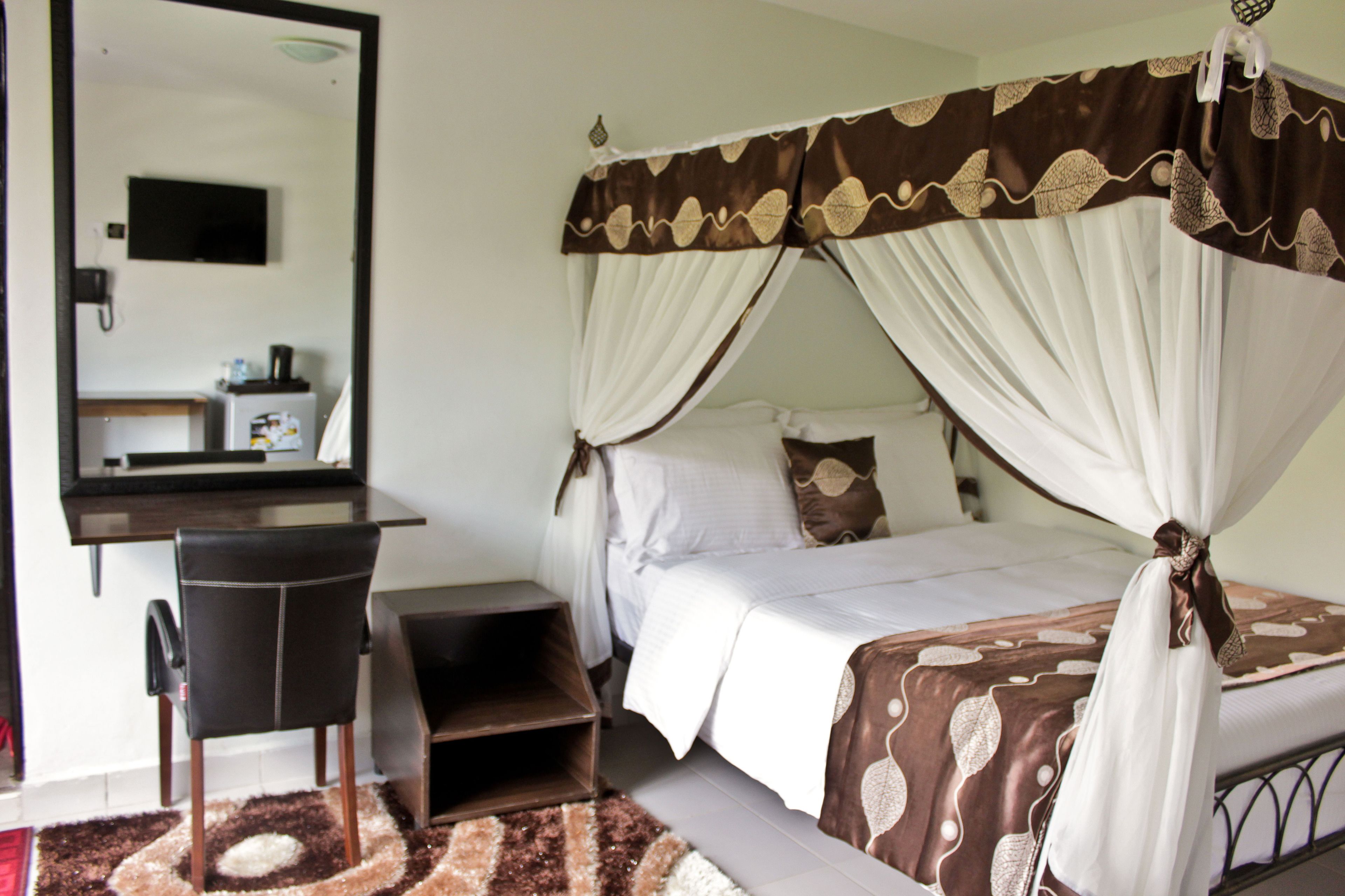 A bedroom with a bed, a desk, and a chair.