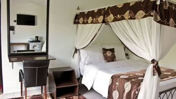 A bedroom with a bed, a desk, and a chair.