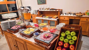 Un bufé con diversas opciones de comida, incluyendo frutas, carnes y bebidas.