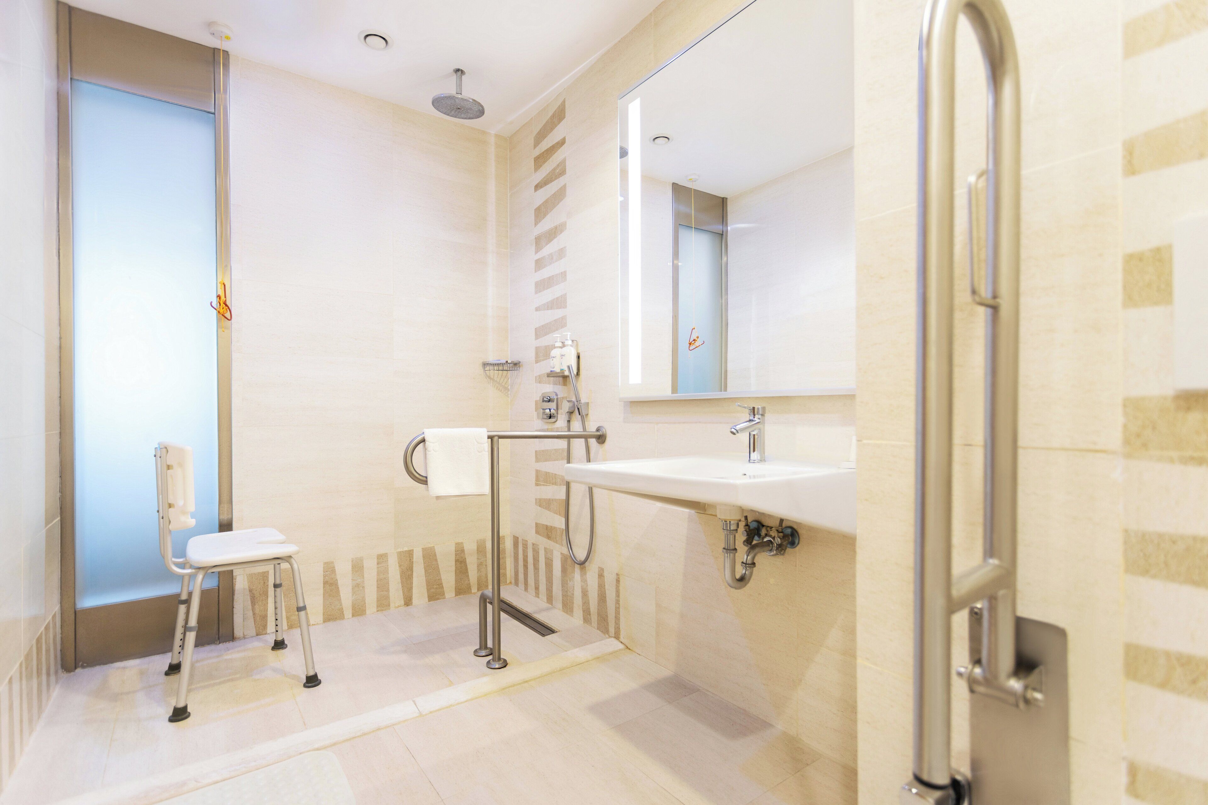A modern bathroom with a shower, a sink, and a toilet.