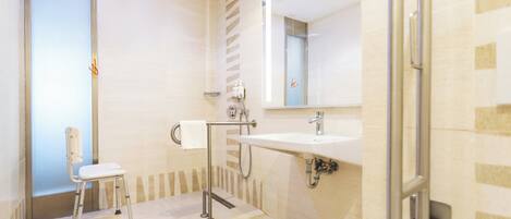 A modern bathroom with a shower, a sink, and a toilet.