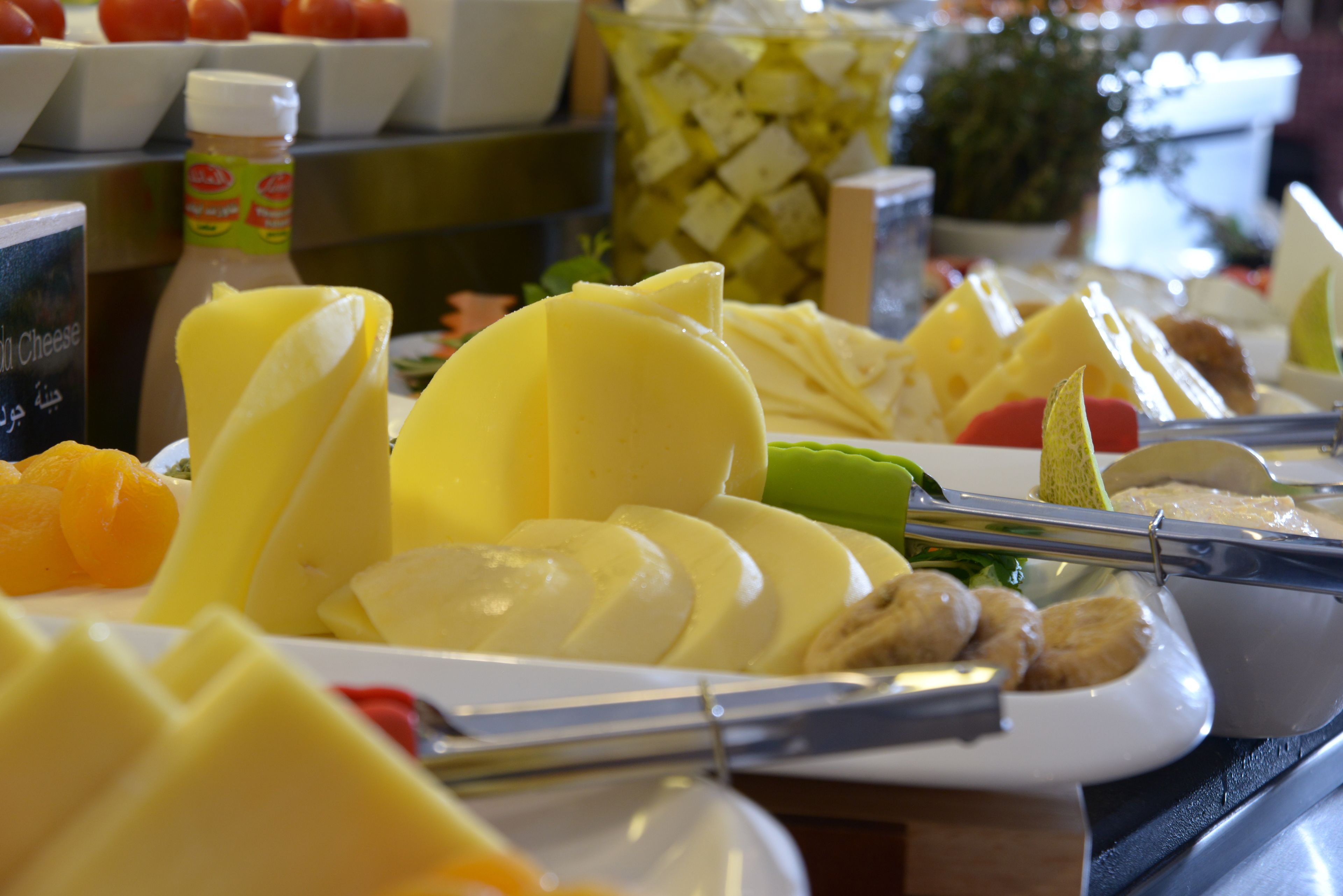 A buffet with various food items including cheese, fruits, and vegetables.