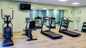 A fitness room with treadmills, an elliptical, and a stationary bike.