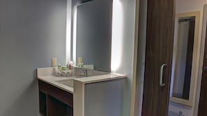 A bathroom with a double sink, a large mirror, and a wooden door. - Holiday Inn Express & Suites Spencer by IHG (Spencer)