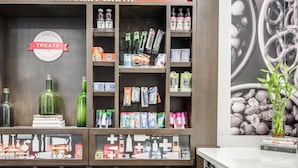 A well-organized store with shelves stocked with snacks, beverages, and toiletries.