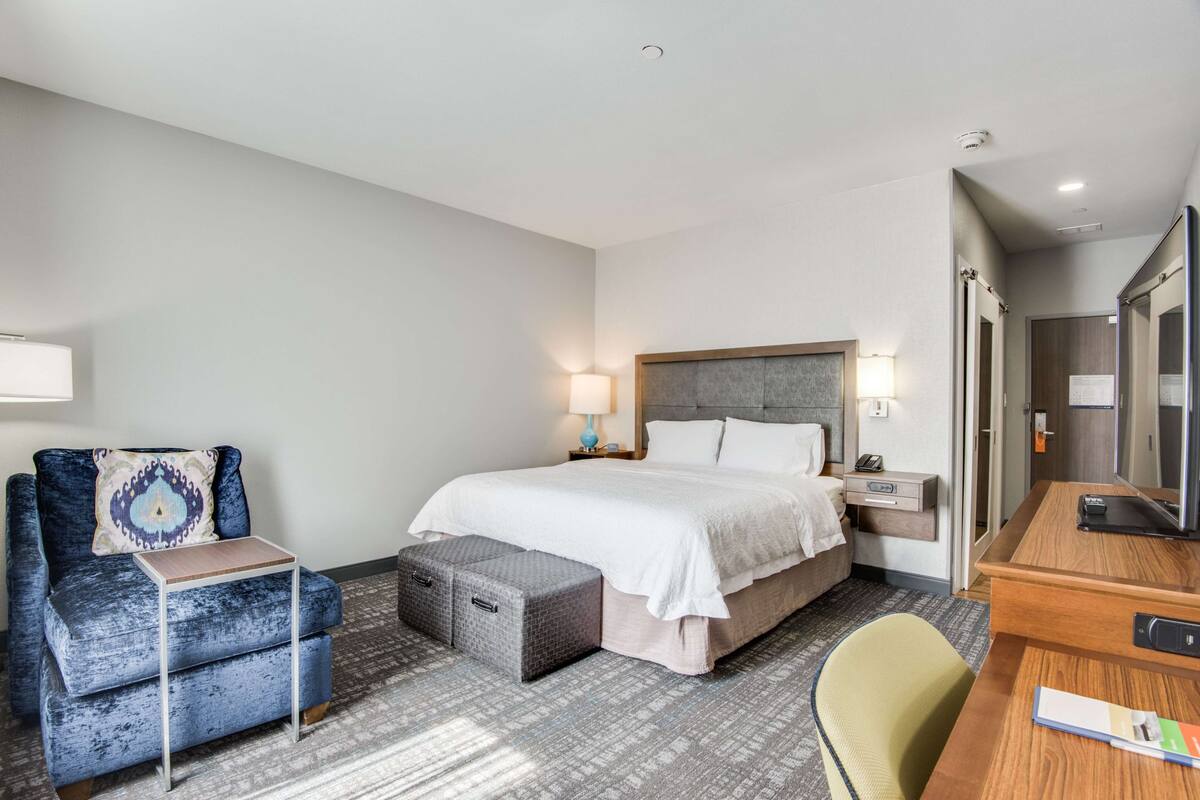 Une chambre d’hôtel comprenant un lit, un bureau, une chaise, un canapé et une petite table.