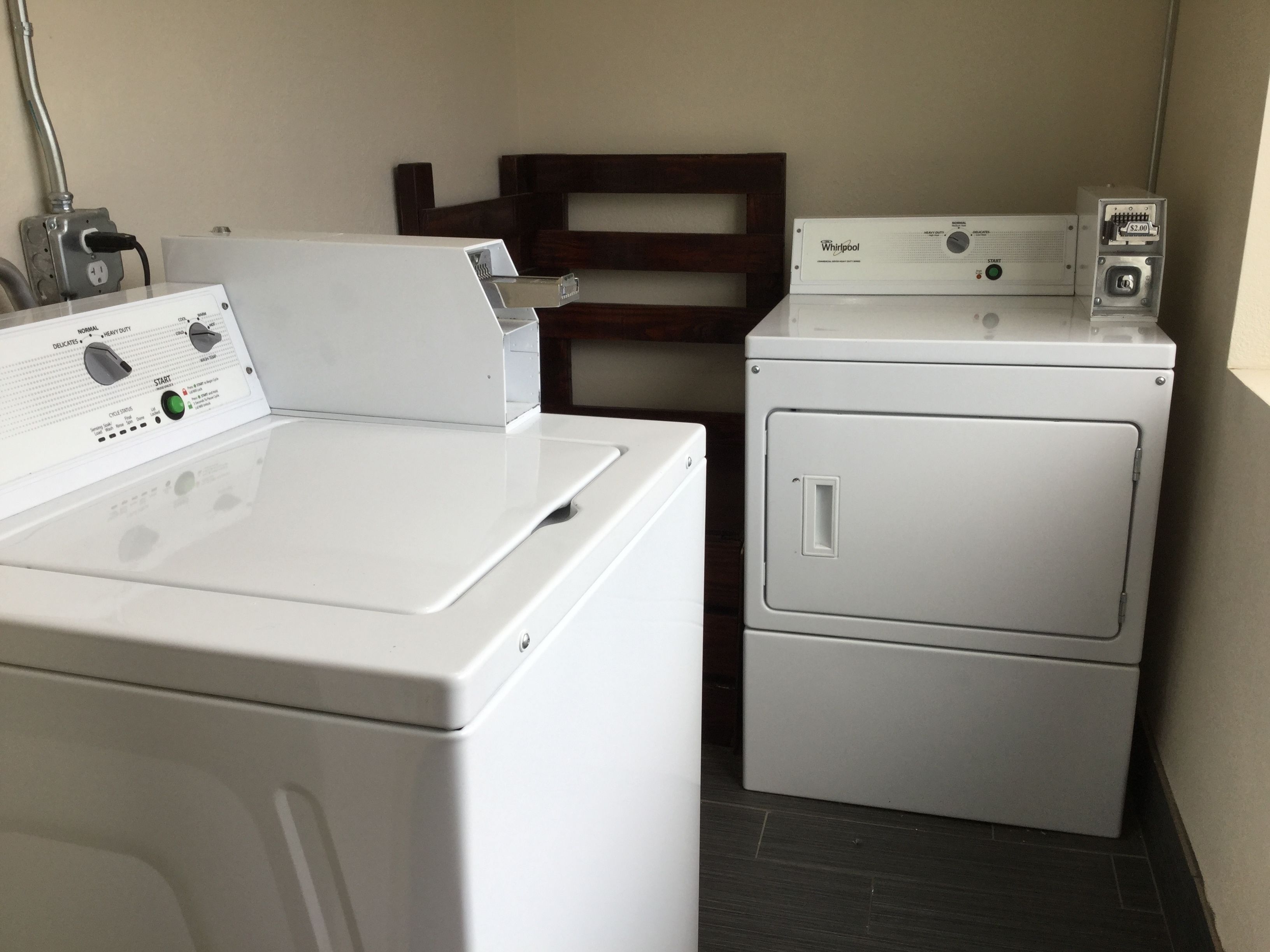 A laundry area with a front-loading washer and a stacked dryer.