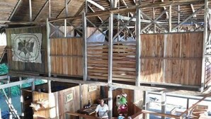 A rustic wooden structure with multiple levels and a staircase. - Kurupira Cabin Floating (Leticia)