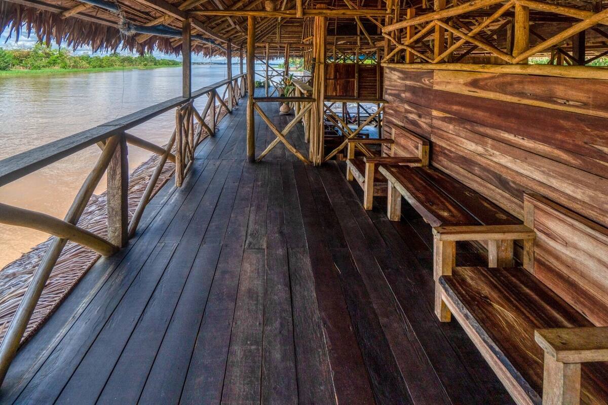 Une terrasse en bois avec des garde-corps donnant sur une rivière.