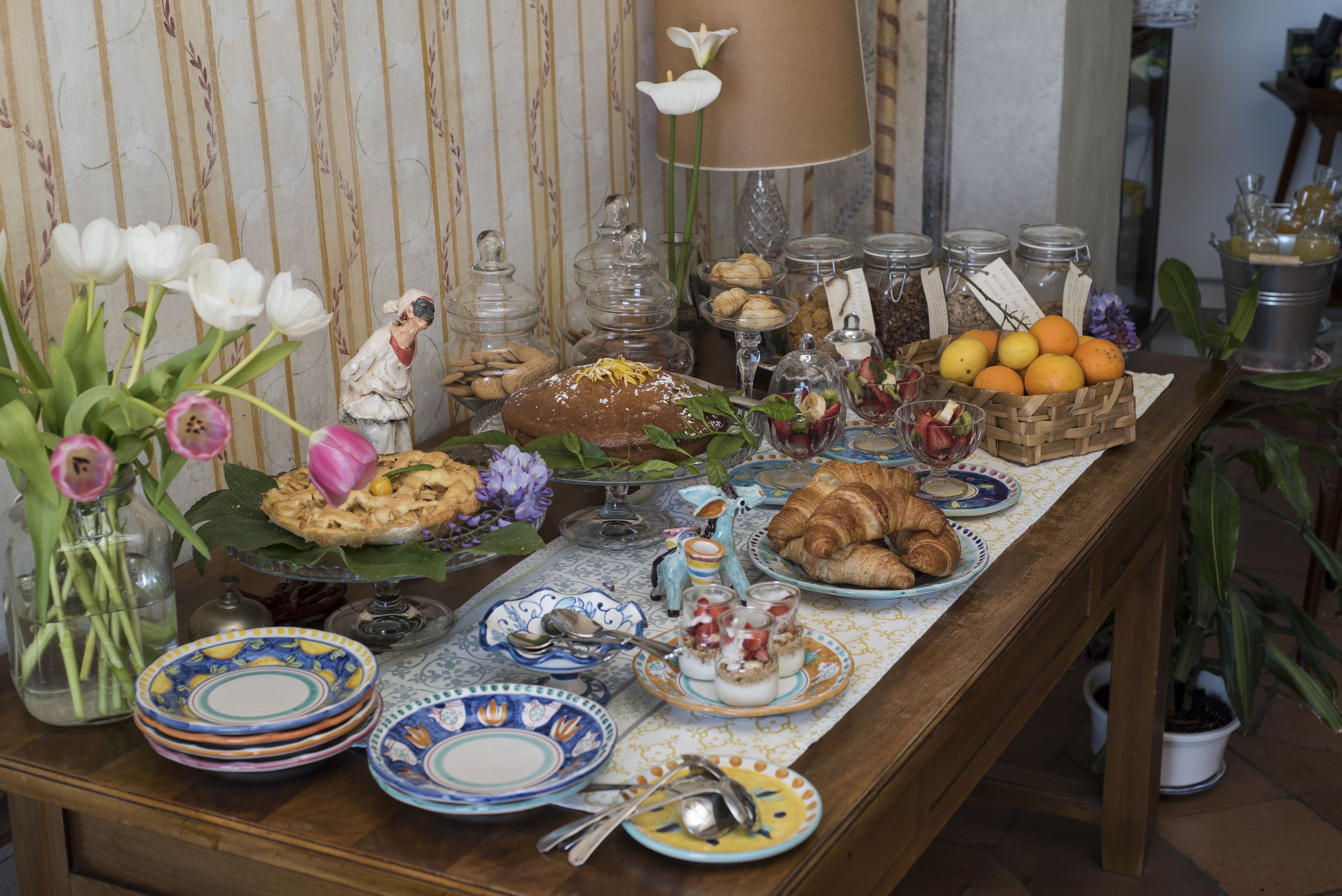 A table with various food items, glassware, and decorative elements.