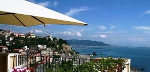 Un paysage urbain côtier avec des bâtiments situés sur une colline surplombant la mer.