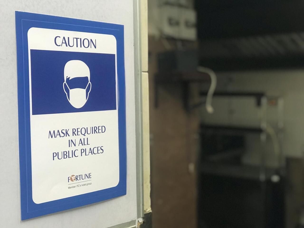 A sign indicating that masks are required in all public places.