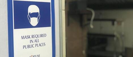 A sign indicating that masks are required in all public places.