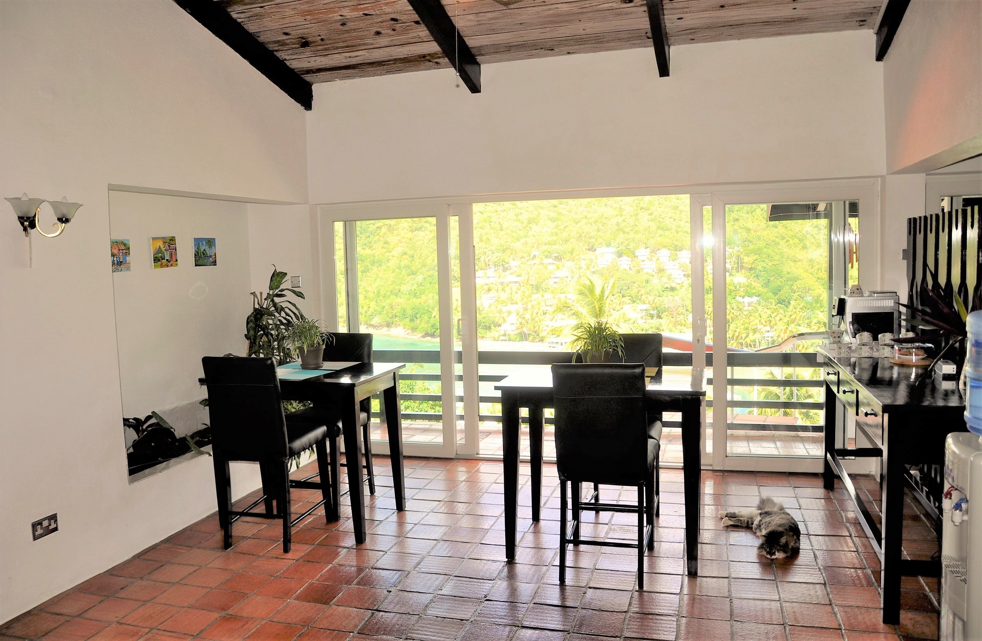 Cocina con comedor, ventanas amplias y vistas a la vegetación.
