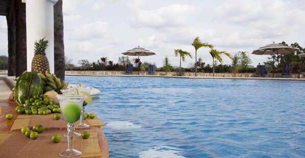 Alberca al aire libre y camastros 