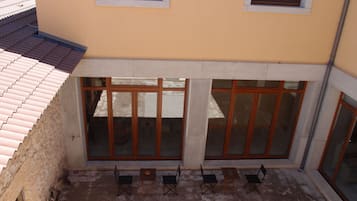 A building with a yellow facade, large windows, and a tiled roof.