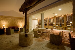 Eine Bibliothek mit Bücherregalen, einem Kamin und bequemen Sitzgelegenheiten.