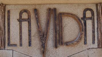 A wall with the word "LAVIDA" in a weathered, rusted font.