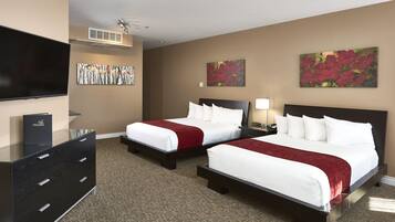 A hotel room with two beds, a flat-screen TV, a dresser, and artwork on the walls.