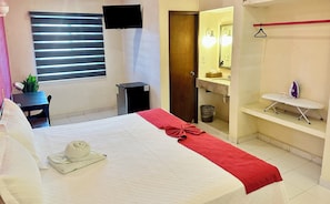 Enjoy a comfortable stay with a neatly made bed, desk, and potted plant.