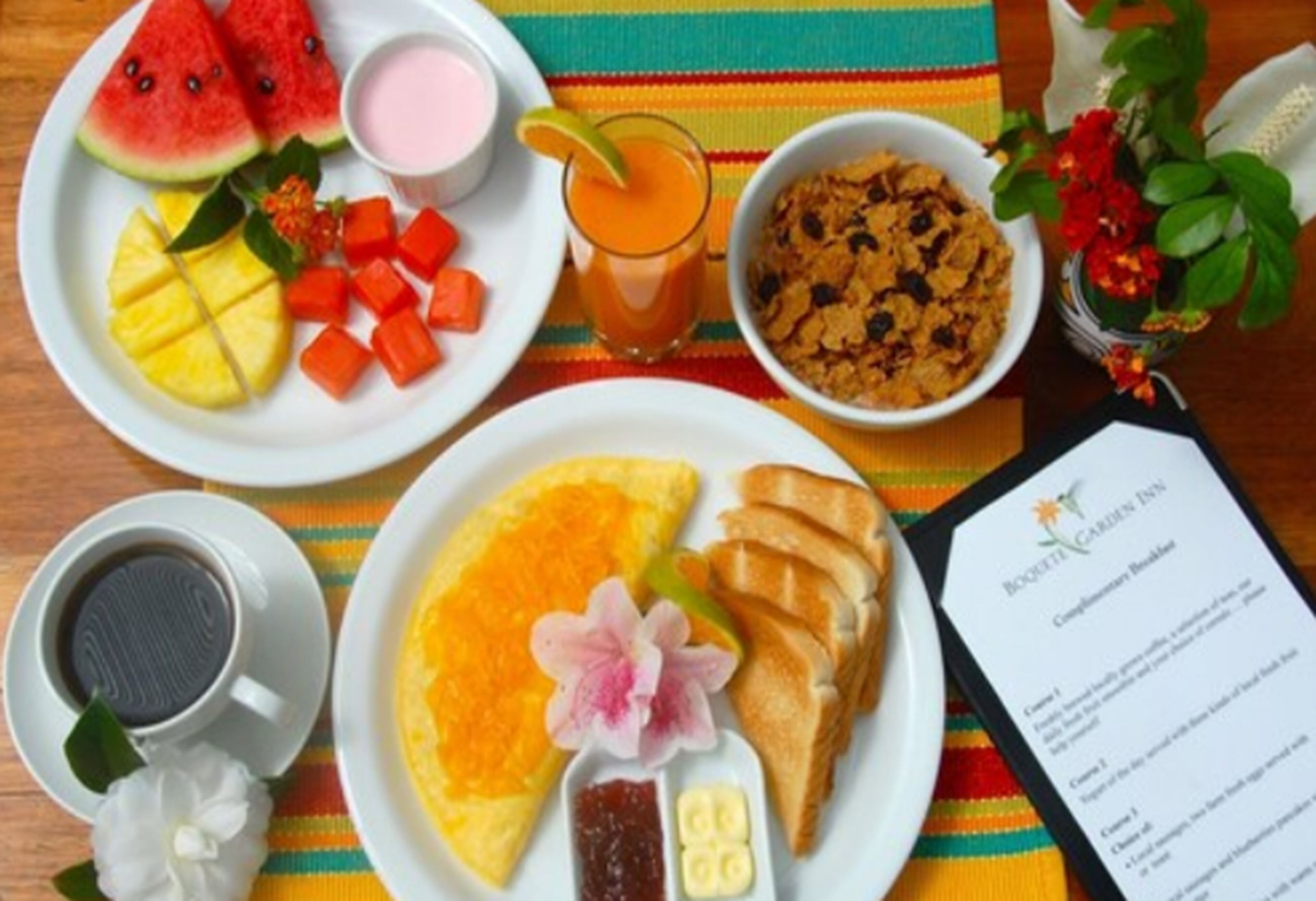 Una mesa de desayuno con platos de fruta, cereal, tostadas y una bebida.