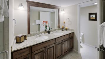 Une salle de bain avec deux lavabos, un grand miroir et des meubles en bois.