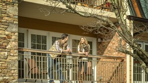 A balcony with stone walls and a metal railing. - Lantern Lodge Asheville Biltmore Village (Asheville)