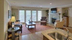 A spacious living area with a fireplace, a dining table, and comfortable seating.