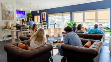 A modern lounge area with sofas and a coffee bar.