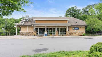 A building with a covered entrance, a picnic table, and a sign indicating a business.