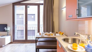Une cuisine moderne avec un coin repas, une grande fenêtre et une vue sur l’extérieur.