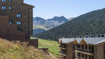 Un bâtiment en pierre doté de nombreux balcons et offrant une vue sur les montagnes.