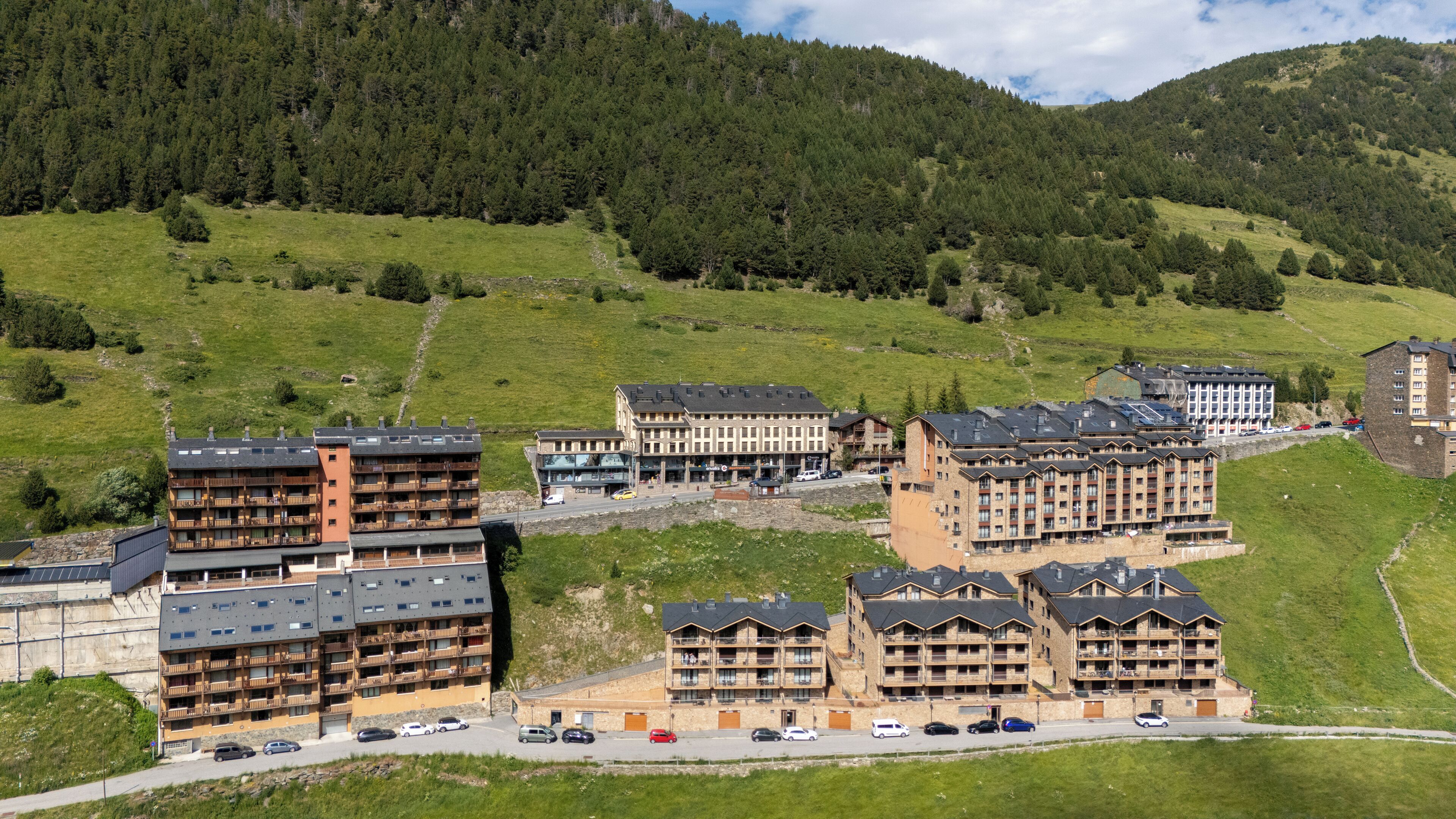 A hotel complex with multiple buildings, including a large central building with balconies and smaller attached structures.