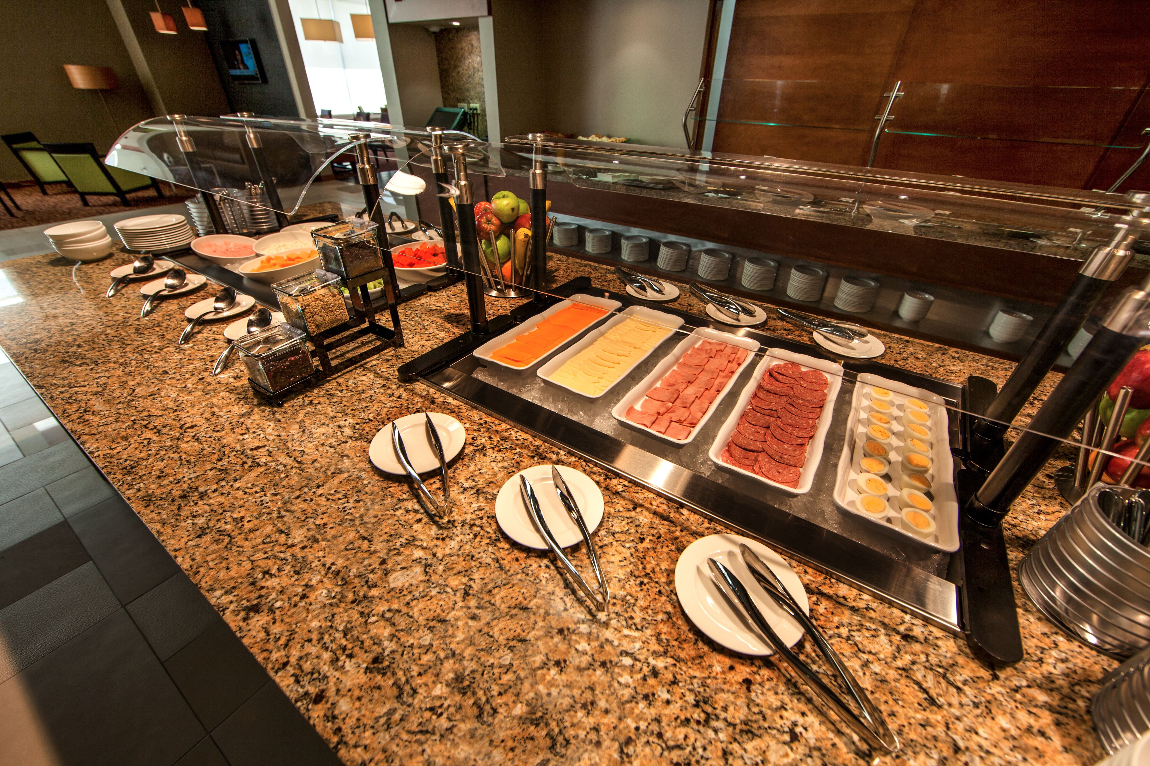 A buffet with various food items and utensils.