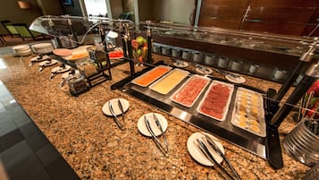 A buffet with various food items and utensils.
