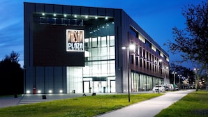 Een modern gebouw met een grote glazen gevel en een bord waarop staat: Warsaw Plaza Hotel.