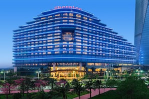 A modern hotel with a curved facade, multiple floors, and a prominent entrance. - Sheraton Zhuhai Hotel (Zhuhai)